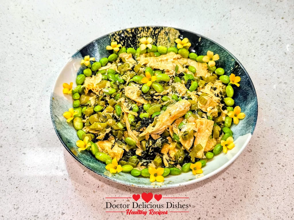 Finished tofu skin recipe plated with edamame and edible flowers for garnish.