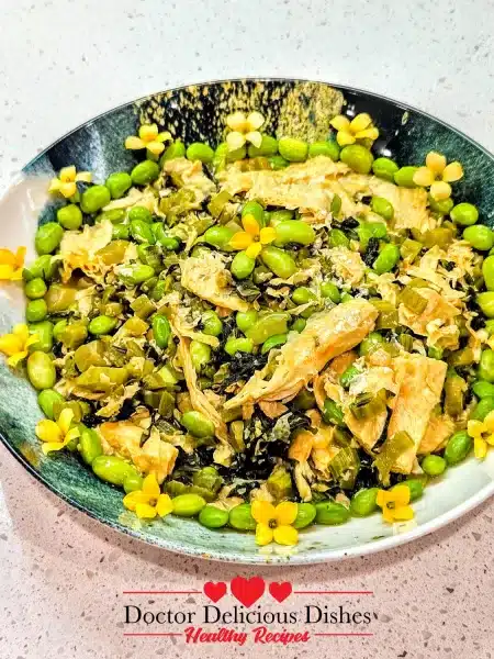 Finished tofu skin recipe plated with edamame and edible flowers for garnish.