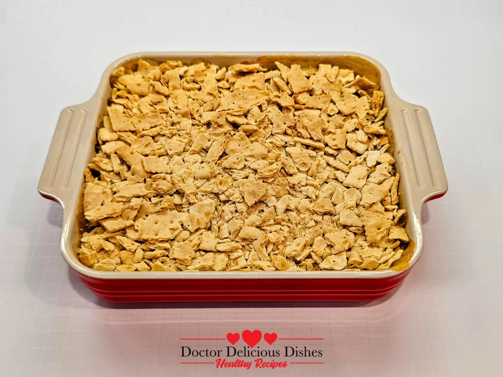Easy Corn Casserole Recipe baked in a red dish with golden cracker topping.