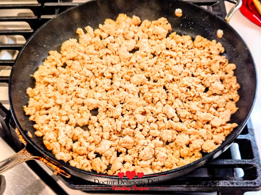 Nonstick pan sprayed with avocado oil heating on stove for Chicken Soboro Don cooking by Doctor Delicious Dishes.