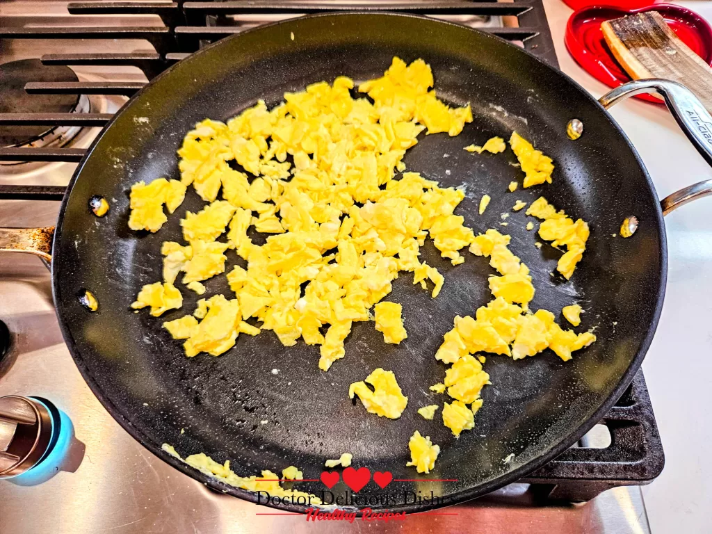 Soft scrambled eggs cooking in a nonstick skillet for Chicken Soboro Don by Doctor Delicious Dishes.