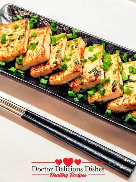 Close-up of Tofu with Oyster Sauce showing crispy edges and green onion garnish.