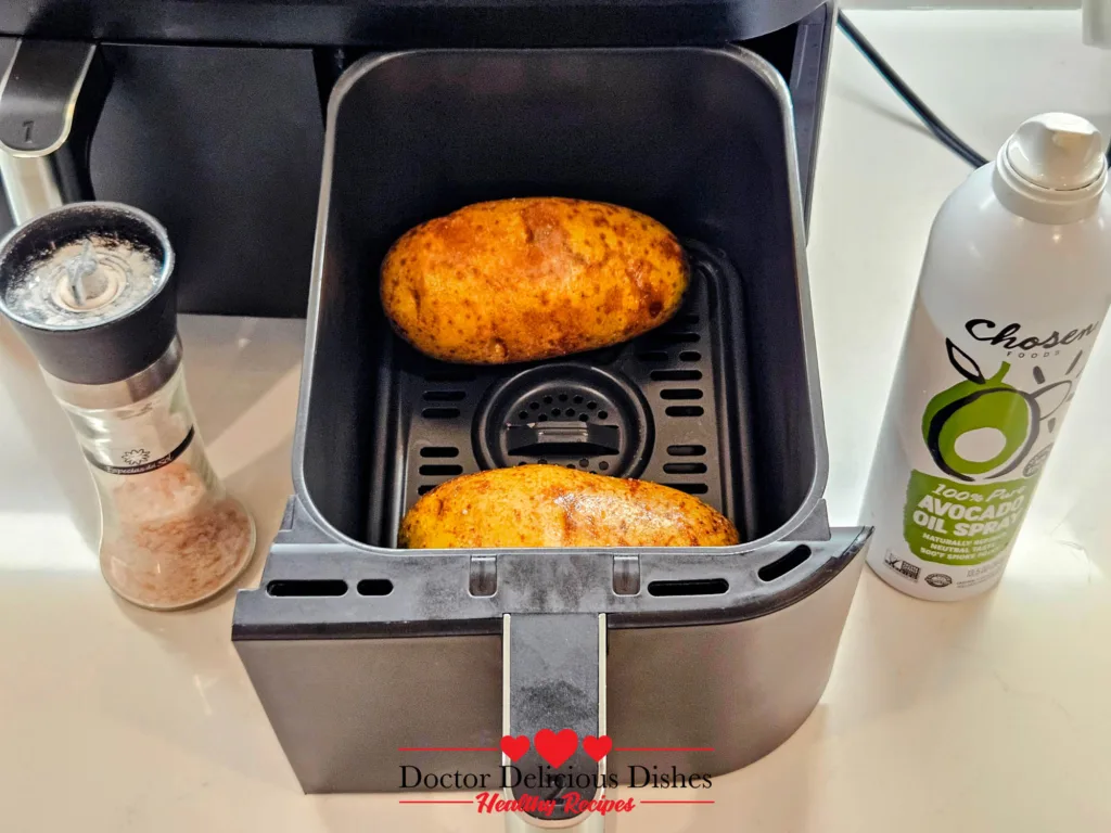 Russet potatoes ready for air frying with avocado oil spray and pink salt