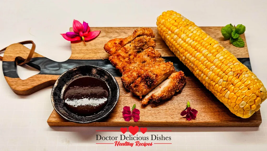 Air Fryer Chicken Katsu with Air Fryer Corn on the Cob on a wooden serving board with dipping sauce