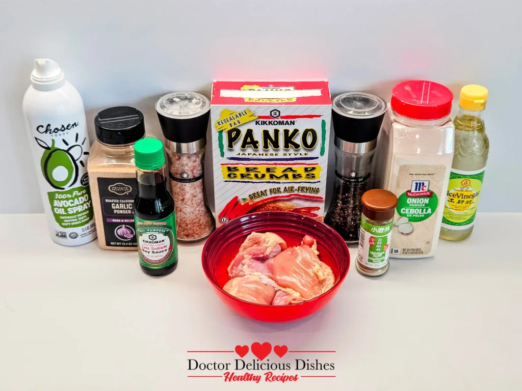 Ingredients laid out for making air fryer chicken katsu, including chicken thighs, panko, seasonings, and avocado oil spray.