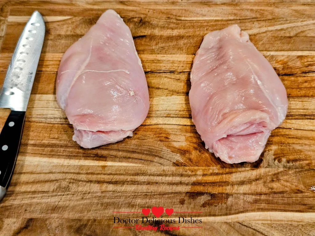 raw chicken breasts on cutting board before stuffing for air fryer stuffed chicken breast