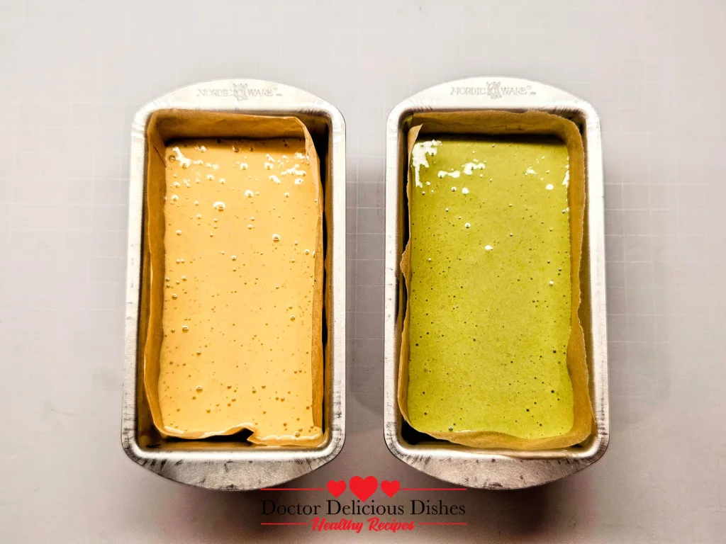 Honey and matcha castella cake batter poured into parchment-lined Nordic Ware mini loaf pans.