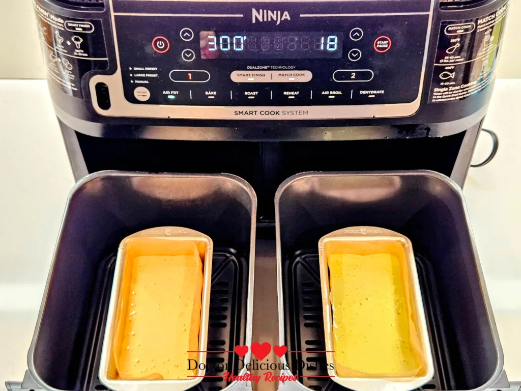 Unbaked honey and matcha castella batter in Nordic Ware pans placed in Ninja DZ550 baskets