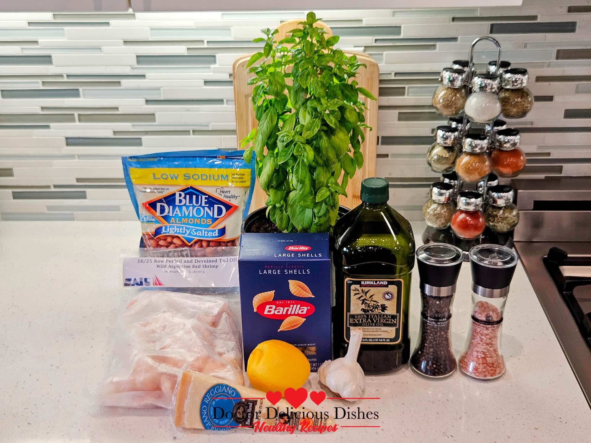 Ingredients for Almond Pesto Shrimp Pasta with shrimp, shells, basil, almonds, olive oil, garlic, lemon, Parmesan, salt, and pepper.