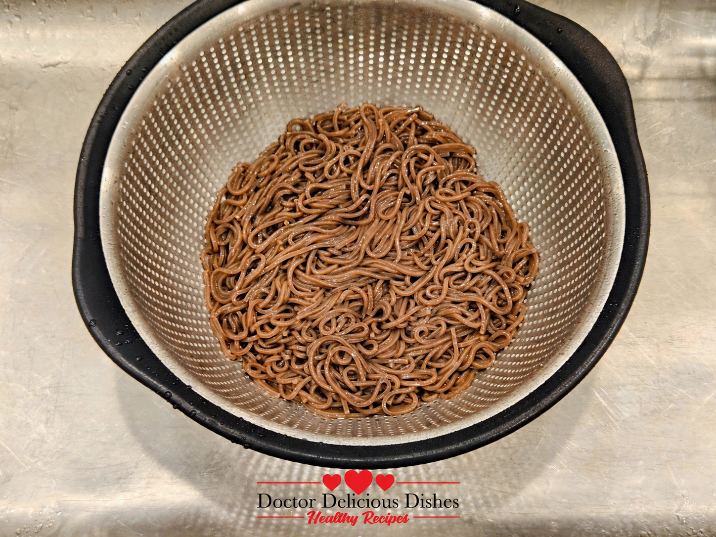 Cooked cold soba noodles drained in a colander after rinsing
